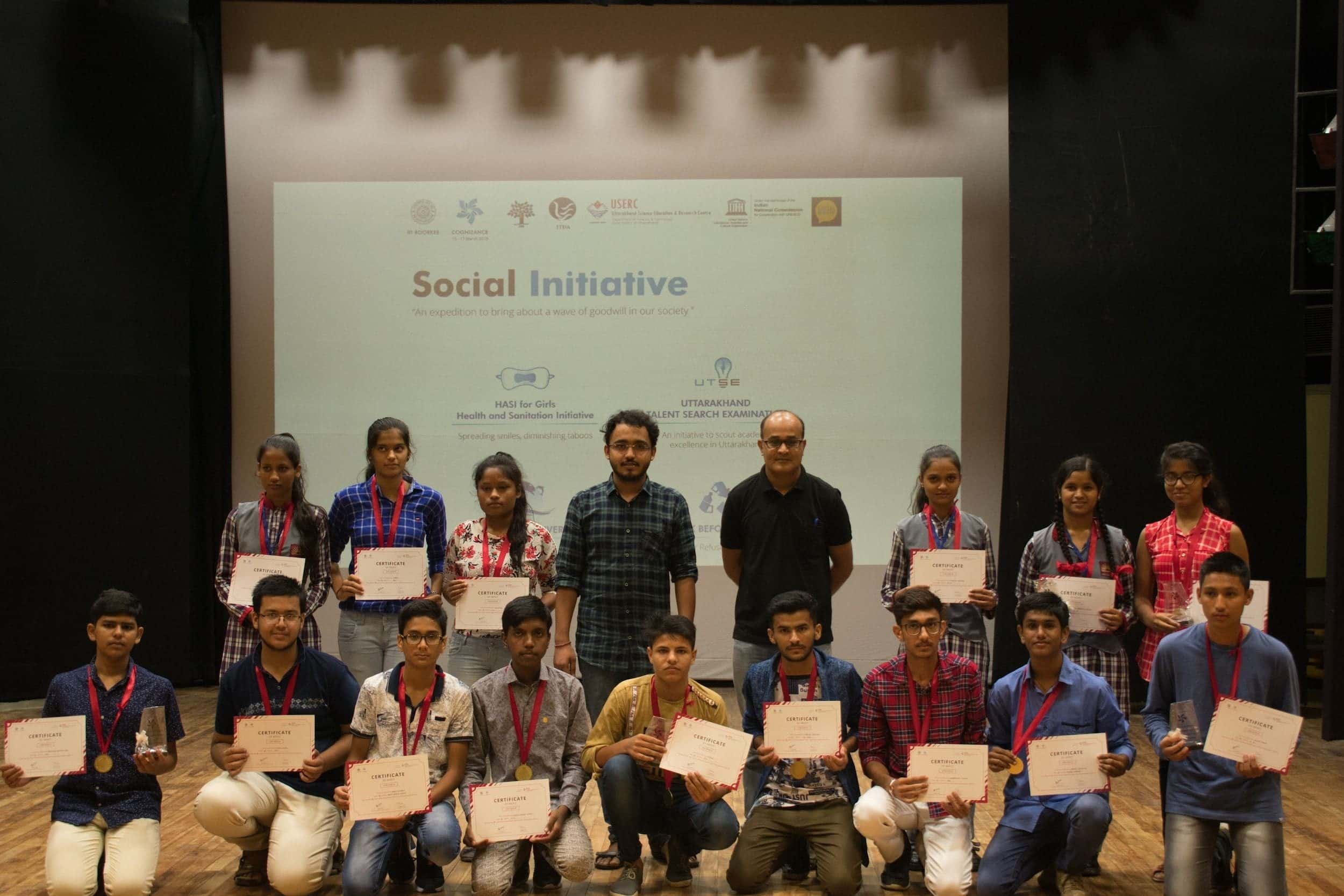 Students holding certificates on stage at an IIT Roorkee event.