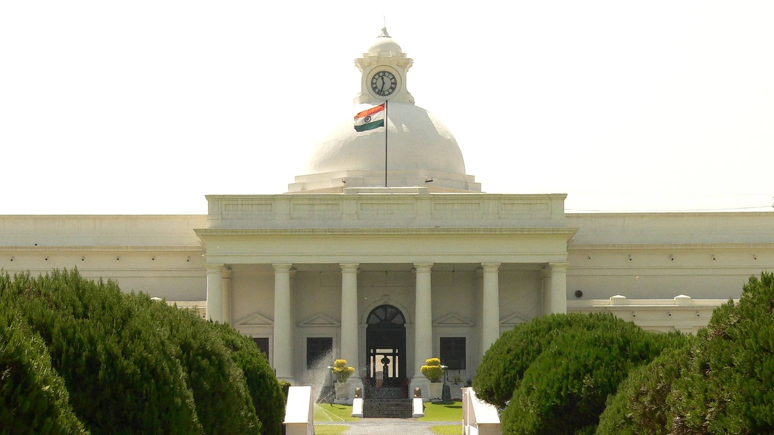 Front of the Main Building with its clock dome and the national flag.