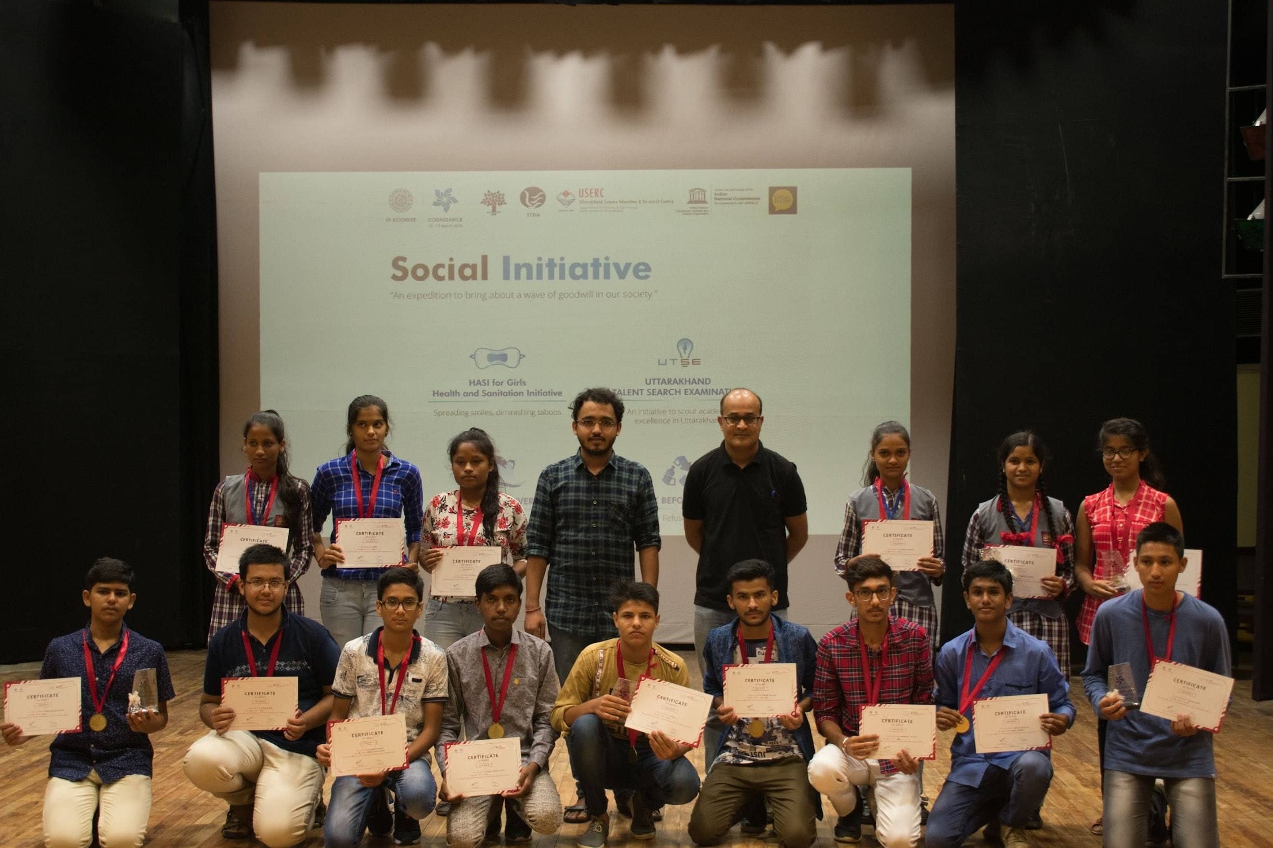 Students holding certificates on stage at an IIT Roorkee event.